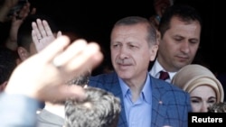 Turkey's Prime Minister Regep Tayyip Erdogan acknowledges supporters outside a polling station in Istanbul March 30, 2014.