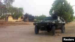 Watamotar soja tana gadi a kifar wani gida da aka kona a garin Bama, Jihar Borno, ran 7 Mayu 2013 