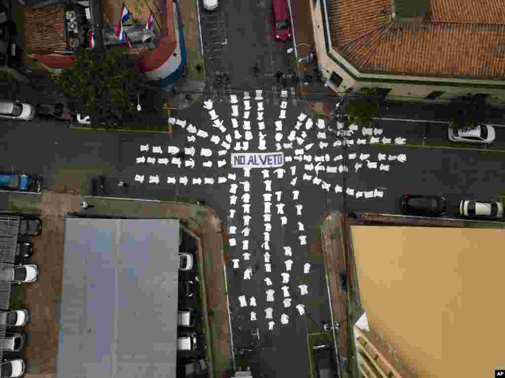 អាវ​វេជ្ជបណ្ឌិត​ពណ៌សត្រូវ​បាន​គេ​តម្រៀប​នៅ​តាម​ផ្លូវ​នៅ​ជុំវិញ​សារ​ដែល​សរសេរ​ថា​&laquo;No to the veto&raquo; សម្រាប់​ប្រធានាធិបតី Mario Abdo Benítez ស្នើ​សុំ​កុំឲ្យ​យល់ព្រម​អនុម័ត​ច្បាប់​ដែល​នឹង​ឲ្យ​វេជ្ជបណ្ឌិត​ទាំង​នៅ​ស្ថាប័ន​រដ្ឋ​និង​ឯកជន​ចូល​និវត្ត​បន្ទាប់​ពី​បាន​បំពេញ​ការងារ​២៥​ឆ្នាំ​នៅ​ក្នុង​ទីក្រុង​ Asuncion ប្រទេស​ប៉ារ៉ាហ្គាយកាលពី​ថ្ងៃទី​២០ ខែឧសភា ឆ្នាំ២០១៩។ &nbsp;