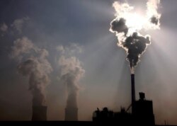 FILE- A coal-burning power plant behind a factory in China's Inner Mongolia Autonomous Region, Oct. 31, 2010.