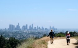 Walkers use recently re-opened hiking paths inside Griffith Park, May 14, 2020, in Los Angeles.