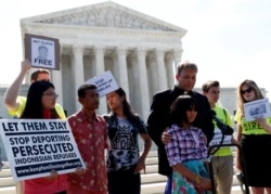 FILE - Naomi Lien is comforted by Pastor Seth Kaper-Dale as they react outside the U.S. Supreme Court after justices upheld President Donald Trump's travel ban targeting several Muslim-majority countries, in Washington, June 26, 2018.
