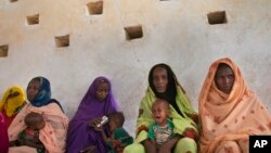 FILE - Mothers wait for their children to be examined for signs of malnutrition at a walk-in nutrition clinic in Barrah, a desert village in the Sahel belt of Chad, April 20, 2012.