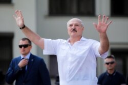 Belarusian President Alexander Lukashenko gestures as he greets his supporters gathered at Independent Square of Minsk, Belarus, Aug. 16, 2020.