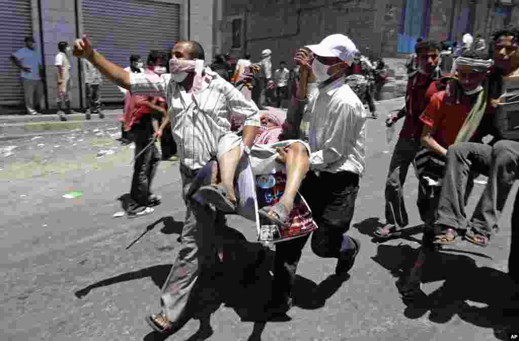 April 5, 2011: Anti-government protestors carry a wounded man during clashes with Yemeni forces in Taiz.