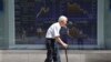 FILE - An elderly man walks by an electronic stock board of a securities firm in Tokyo, Aug. 19, 2016. Elderly healthcare poses significant fiscal challenges all across Asia, experts say.