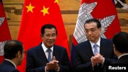 រូបឯកសារ៖ លោក​នាយករដ្ឋមន្ត្រី ហ៊ុន សែន ទះដៃ​ជាមួយ​នឹង​នាយករដ្ឋមន្ត្រី​ចិន លោក Li Keqiang ក្នុង​អំឡុងពេល​នៃ​ពិធី​ចុះ​ហត្ថលេខា​មួយ​នៅ​ឯ​មហាសាល​ប្រជាជន​ក្នុង​ទីក្រុង​ប៉េកាំង ប្រទេស​ចិន ថ្ងៃ​ទី២២ ខែមករា ឆ្នាំ​២០១៩។