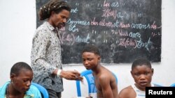 Cedrick Tshimbalanga, 32, the founder of Mokili Na Poche cultural centre, uses his phone while talking to homeless teenagers during a lunch at the cultural center in Kinshasa, Democratic Republic of Congo September 5, 2023. (REUTERS/Justin Makangara)