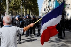 A protester holds a French flag as he takes part in a demonstration on Act 45 (the 45th consecutive national protest on Saturday) of the yellow vests movement in Paris, France, Sept. 21, 2019.