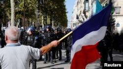 A protester holds a French flag as he takes part in a demonstration on Act 45 (the 45th consecutive national protest on Saturday) of the yellow vests movement in Paris, France, Sept. 21, 2019. 