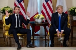 President Donald Trump, right, listens as French President Emmanuel Macron speaks at their meeting at Winfield House during the NATO summit, in London, Dec. 3, 2019.