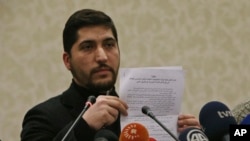 Osama Abu Zeid dari kelompok oposisi moderat Tentara Pembebasan Suriah, menunjukkan salinan surat perjanjian gencatan senjata untuk Suriah, dalam konferensi pers di Ankara, Turki (29/12). (AP/Burhan Ozbilici)