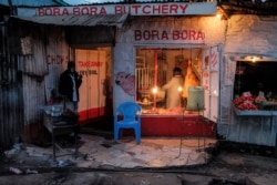 A butcher makes a fresh cut of meat for a customer just before the 7 p.m. curfew in Nairobi, Kenya, May 5, 2020.