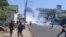 Protesters run from tear gas in Blantyre, Malawi, Nov. 19, 2021. (Lameck Masina/VOA)