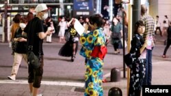 Women in summer kimonos advertise for a bar that stays open after 8 p.m., when most of the restaurants and bars in the Kabukicho nightlife area close due to the state of emergency amid the COVID-19 pandemic, in Tokyo, Japan July 31, 2021. 