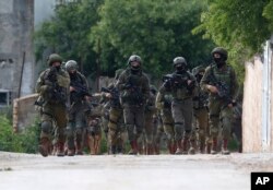 Israeli forces search for a Palestinian gunman in the village of Bruqin near the West Bank town of Salfit, March 17, 2019. The Israeli military says a Palestinian killed an Israeli and seriously wounded two others.