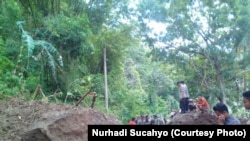 Petugas kepolisian membantu membuka akses yang terputus akibat longsor di Yogyakarta. (VOA/Nurhadi Sucahyo)