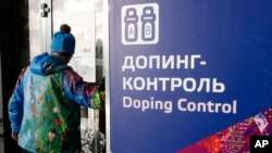 A man walks past a sign reading doping control, at the Laura biathlon and cross-country ski center, at the 2014 Winter Olympics in Krasnaya Polyana, Russia, Feb. 21, 2014.