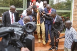 FILE - Uganda's prominent opposition politician Robert Kyagulanyi known as Bobi Wine, center, walks ahead of appearing at the general court martial in Gulu, northern Uganda, Aug. 23, 2018.