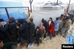 FILE - Internally displaced Syrians line up to receive blankets near the Bab al-Salam crossing, across from Turkey's Kilis province, on the outskirts of the northern border town of Azaz, Syria, Feb. 6, 2016.