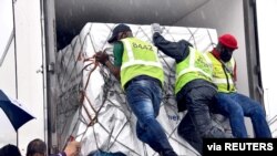 Para pekerja memuat kiriman pertama vaksin saat tiba di Bandara OR Tambo, Johannesburg, Afrika Selatan, 1 Februari 2021. (Foto: Elmond Jiyane for GCIS/Handout)