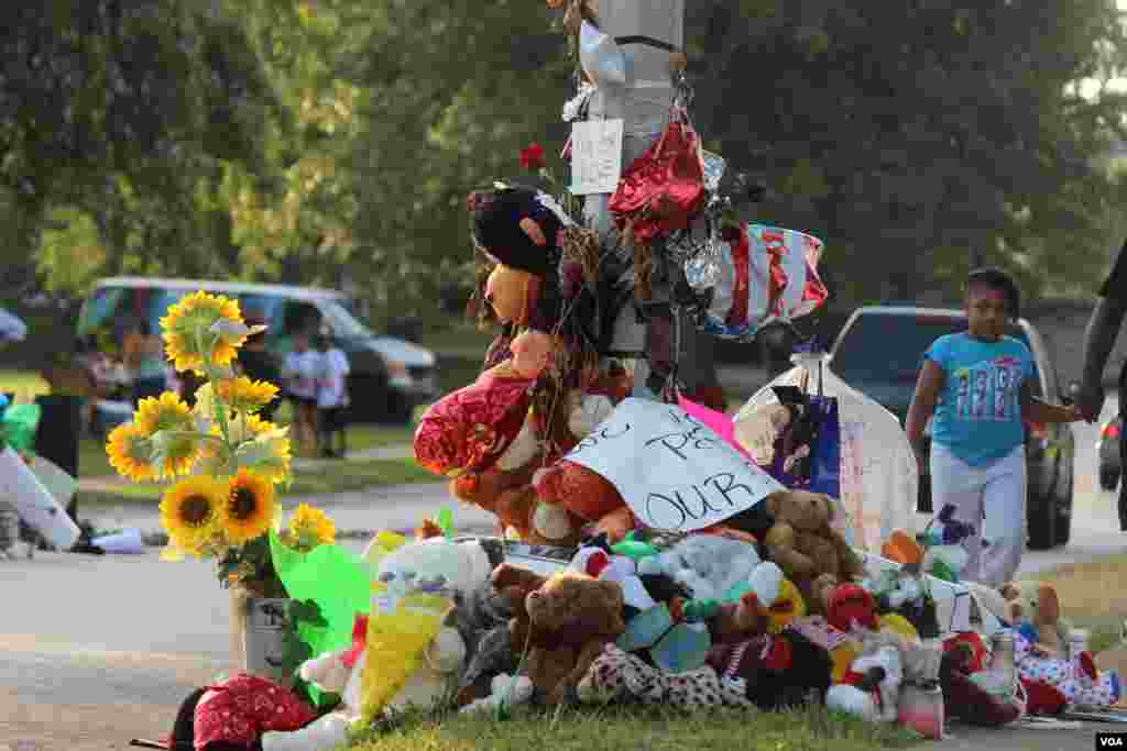 An outpouring of tributes are seen at the site that teenager Michael Brown was shot and killed by a police officer, Ferguson, Missouri, Aug. 24, 2014. (Gesell Tobias, VOA)