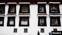 FILE - Pilgrims walk near Jokang Temple, Lhasa, Tibet Autonomous Region, China.