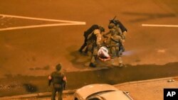 FILE - Police beat a protester at a rally following disputed presidential elections, in Minsk, Belarus, Aug. 11, 2020.