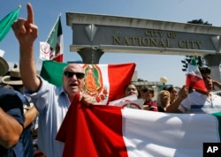 FILE - Immigrant rights activists chant during a sanctuary city rally held in National City, California, Sept. 30, 2006.