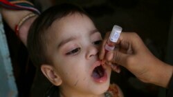 FILE - A health worker administers a polio vaccine to a child in Karachi, Pakistan, Sept. 20, 2021.