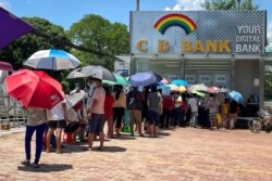 រូបឯកសារ៖ មនុស្សម្នា តម្រង់​ជួរ​នៅ​ខាងក្រៅ​ធនាគារ​ដើម្បី​ដក​ប្រាក់​នៅ​ក្នុង​ទីក្រុង​រ៉ង់ហ្គូន ប្រទេស​មីយ៉ាន់ម៉ា កាលពី​ថ្ងៃទី១៣ ខែឧសភា ឆ្នាំ២០២១។