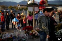 Yanira Perez (2-R) wipes her eyes as she and her mother, Marcela, pay respects at a makeshift memorial to honor the victims of Wednesday's shooting rampage, Dec. 5, 2015, in San Bernardino, California.