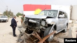 Iraqi Kurdish security forces stand next to the car of Mohammed Younis, a senior official of Iraq's state-run North Gas Company (NGC) who was killed by gunmen, in the northern oil city of Kirkuk, Iraq, May 2, 2017.