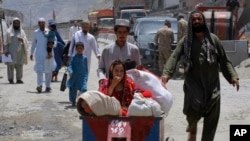 Afghan families arrive at the border crossing in Torkham, Pakistan, Saturday, June 18, 2016.