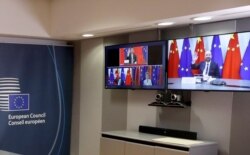 FILE - European Council President Charles Michel, right screen, waves to Chinese President Xi Jinping, left screen top, during an EU-China summit, in videoconference format, at the European Council in Brussels, June 22, 2020.