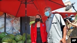 U.S. Rep. Alexandria Ocasio-Cortez, D-N.Y., left, poses for a cell phone photograph with a supporter while greeting voters during the state's primary election outside a grocery store in the Queens borough of New York, June 23, 2020.