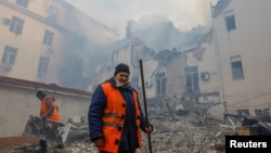 Municipal workers remove debris outside a local railway administration headquarters damaged in shelling in the course of Russia-Ukraine conflict in Donetsk, Russian-controlled Ukraine, Nov. 7, 2022. 