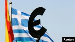 在布鲁塞尔欧洲议会大楼外面，希腊国旗在欧盟标徽后面飘扬。