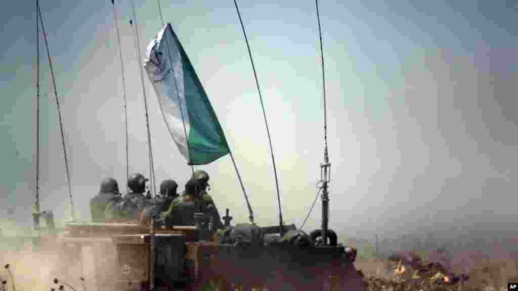 Israeli soldiers on an armored personnel carrier move to a new position on the Israel-Gaza Border, July 12, 2014. 