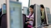 FILE - Vietnamese people work with computers at a media center in Hanoi.