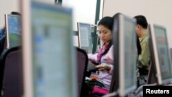 FILE - Vietnamese people work with computers at a media center in Hanoi.