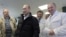 Russia -- businessman Yevgeny Prigozhin, right, smiles as he shows Russian President Vladimir Putin, center, around his factory which produces school means