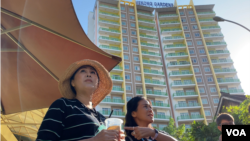 អ្នកស្រី Sitanun Satsaksit (ពាក់មួក) ជាបងស្រី​បង្កើត​របស់​សកម្មជន​ថៃបាត់ខ្លួន គឺលោកWanchalearm Satsaksit ឈរនៅមុខ​ខុនដូ​ក្នុងខណ្ឌ​ជ្រោយចង្វារ រាជធានី​ភ្នំពេញ​នៅថ្ងៃទី៤ ខែធ្នូ ឆ្នាំ២០២០។ អ្នកស្រី​អះអាងថា ខុនដូនេះ លោក Wanchalearm បានរស់នៅ​មុនពេល​បាត់ខ្លួន កា