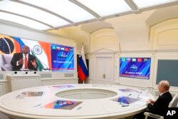 Rais wa Russia Vladimir Putin (Kulia) akishiriki katika mkutano wa Jumuiya ya BRICS kwa njia ya mtandao. Anamsikiliza Rais wa Afrika Kusini Cyril Ramaphosa (kushoto) akihutubia mkutano huo.(Mikhail Klimentyev, Sputnik, Kremlin Pool Photo via AP)