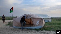 Palestinians set up tents in preparation for mass demonstrations along the Gaza strip border with Israel, in eastern Gaza City, Tuesday, March 27, 2018. (AP Photo/Adel Hana)