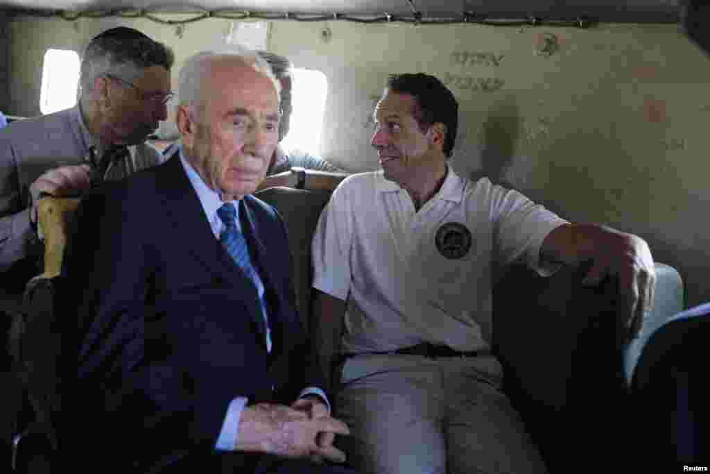 Former Israeli President Shimon Peres (second from left) and New York Governor Andrew Cuomo, right ride an armored vehicle during a tour near the border with the Gaza Strip, Aug. 14, 2014.