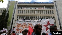 Para demonstran melakukan protes atas penutupan penyiaran publik ERT di depan kantor ERT di Athena, Yunani (13/6). 
