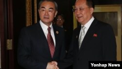 25일 라오스 비엔티안에서 열린 북-중 양자회담에 앞서 중국 왕이 외교부장(왼쪽)이 북한 리용호 외무상과 악수하고 있다.