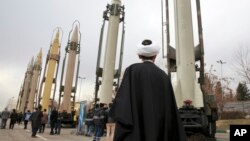 FILE - An Iranian clergyman looks at domestically built surface-to-surface missiles displayed by the Revolutionary Guard in a military show marking the 40th anniversary of the Islamic Revolution, at Imam Khomeini Grand Mosque in Tehran, Iran, Feb. 3, 2019.