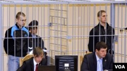 Dmitry Konovalov (kiri) dan Vladislav Kovalev berdiri dalam kurungan selama persidangan di Minsk, Belarus. Keduanya dijatuhi hukuman mati atas serangan bom di stasiun kereta bawah tanah, April 2011 (Foto: dok).